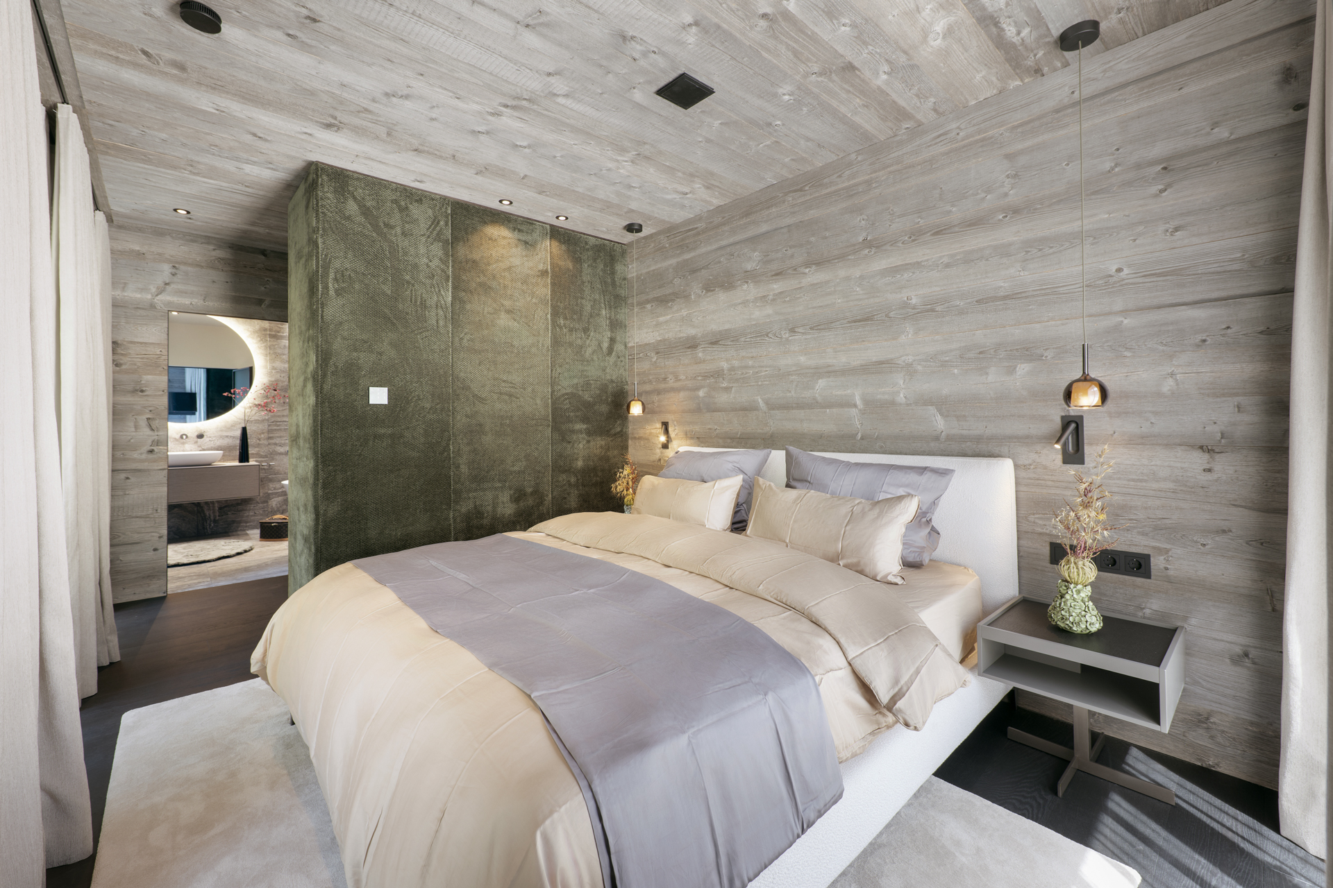 Schlafzimmer mit dunklen Holzwänden und Balkon mit Bergblick
