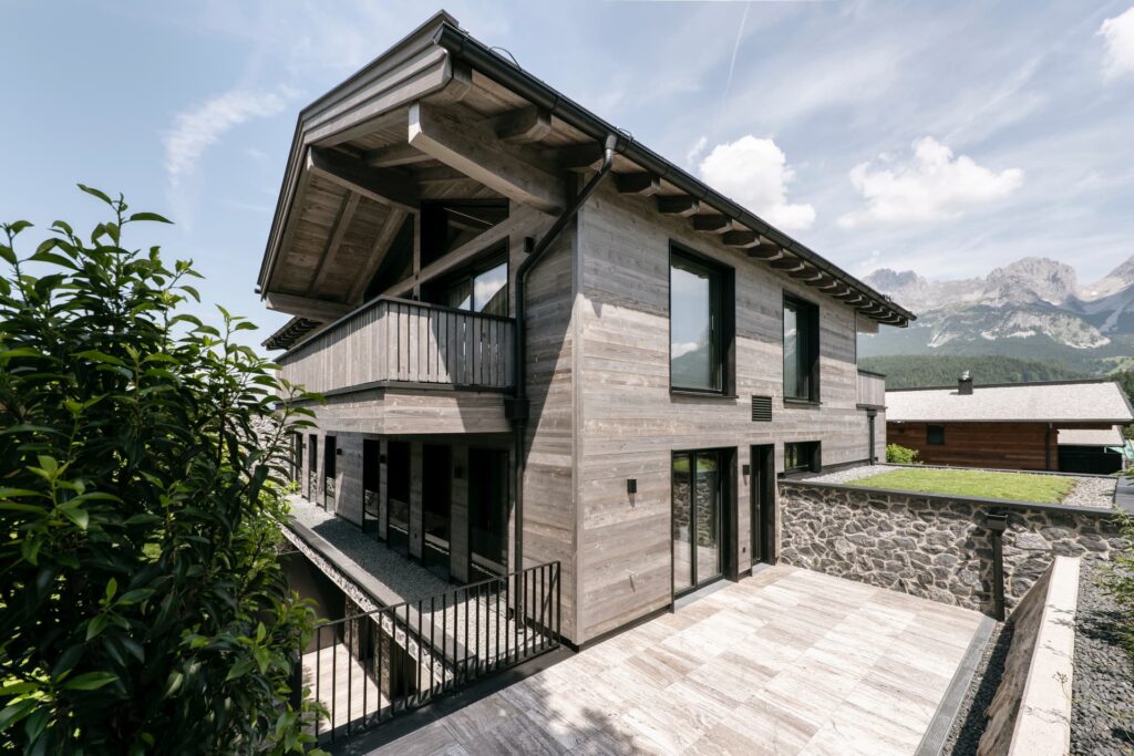 Fassade aus dunklem Naturstein und Altholz